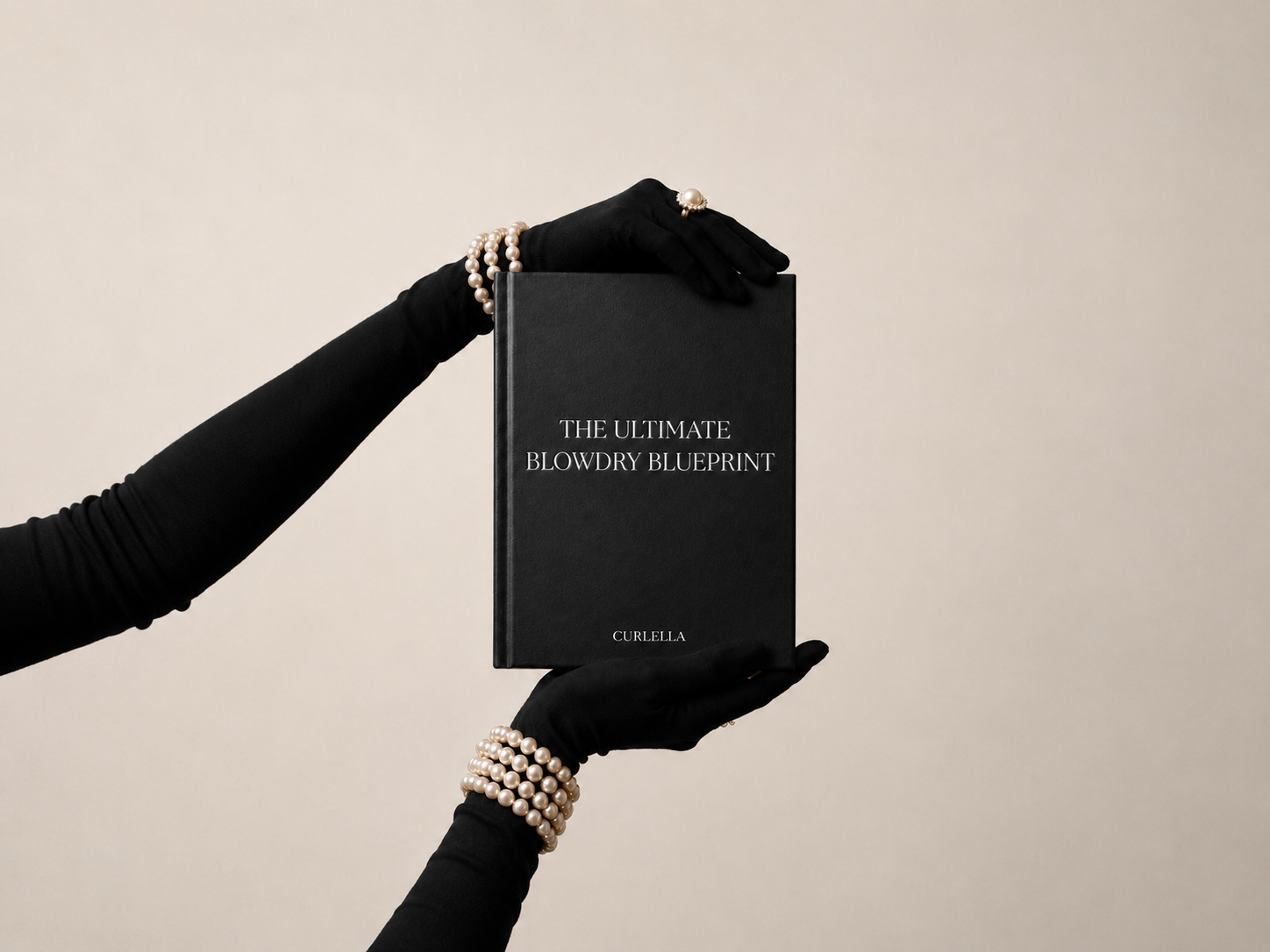 A person wearing black long-sleeve gloves and pearl bracelets holds a black book titled 'THE ULTIMATE BLOWDRY BLUEPRINT' against a plain beige background.