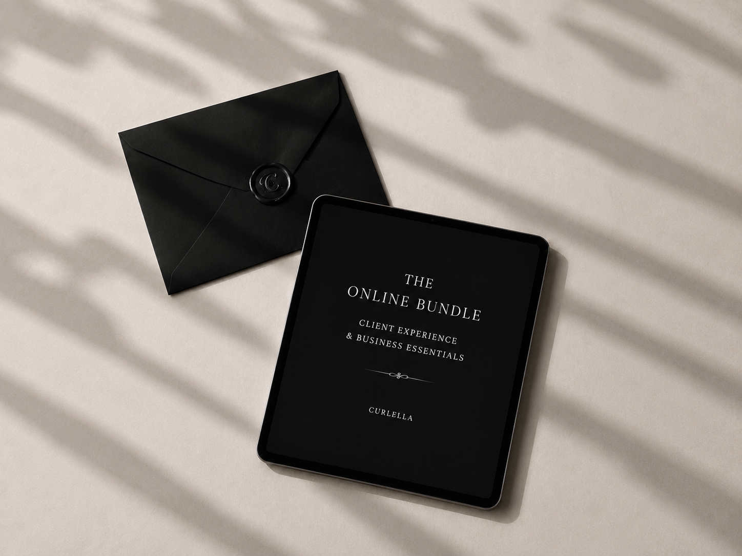 A black tablet displaying 'THE ONLINE BUNDLE' with the CURZELLA brand name, placed next to a matching black envelope on a light beige surface with soft shadow overlays.